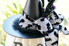 21 a creative centerpiece of a white pumpkin with letters, a witch hat with a bow and feathers for Halloween