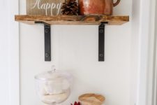 26 wooden shelves, a sign, a copper pot with eucalyptus, some soaps in a jar and a bloom make up a pretty fall arrangement
