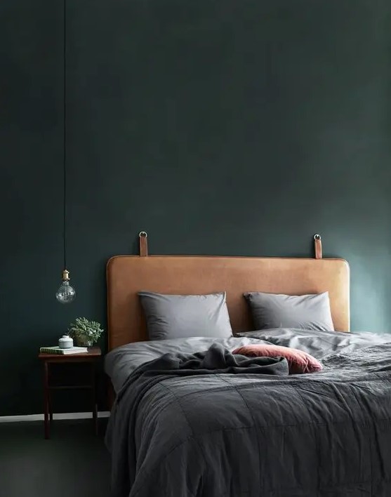 a brown leather headboard with metal rings brings a light industrial feel