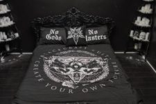 a moody Halloween bedroom in black is spruced up with some white touches – faux fur, candles, skulls and a moon artwork