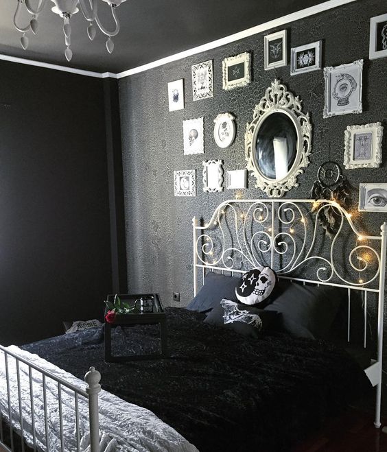 a moody Halloween bedroom in black, with a scary gallery wlal, a mirror and some cool spooky pillows