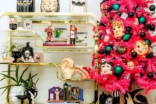 a pink Halloween tree with black and green ornaments, masks and feathers is a bold and spooky statement for a party