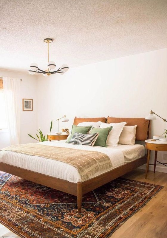 a stylish stained wooden bed with a pillow headboard and round nightstands for creating a welcoming space