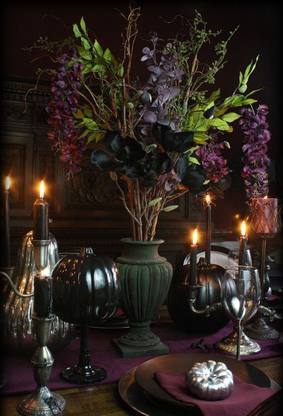 a tall matte black urn with greenery and dark leaves plus candles around are amazing for Halloween decor