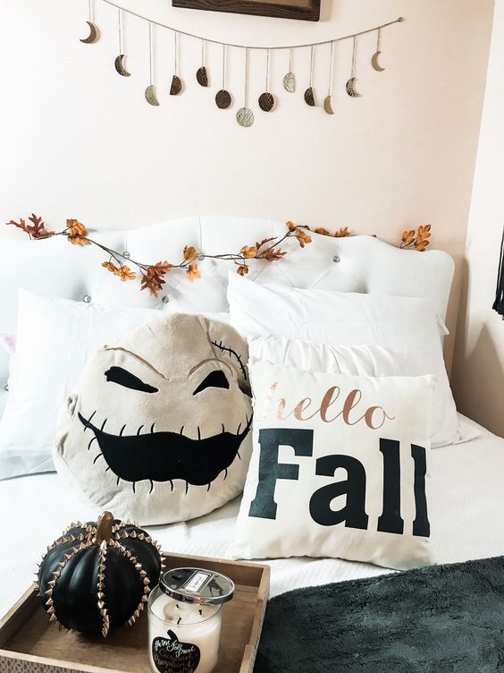 add a scary pillow, a spiked pumpkin and a moon phase garland over the bed to make your bedroom more Halloween-like