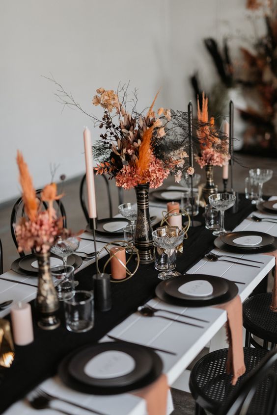 bright Halloween centerpieces of black and orange grasses, blooms and leaves are super chic and cool