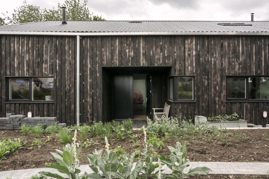 This home used to be a usual tractor shed, which was renovated and turned into a home, it was clad with scorched wood and resembles a barn