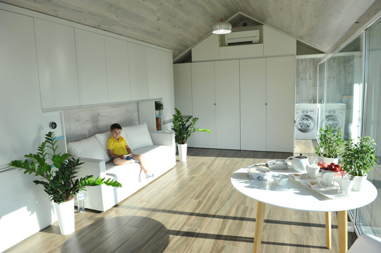 living room design in a minimalist style The house features a minimalist interior and everything you may need is smartly hidden inside sleek white panels