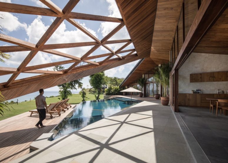 The indoor spaces are opened to outdoors with sliding doors and a sculptural geometric roof creates a seamless transition between them