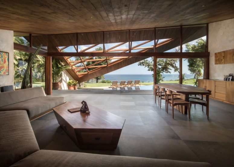 Inside there's a large social area with a kitchen, a dining space and a living room, with contemporary furniture and a geometric coffee table Inside there's a large social area with a kitchen, a dining space and a living room, with contemporary furniture and a geometric coffee table