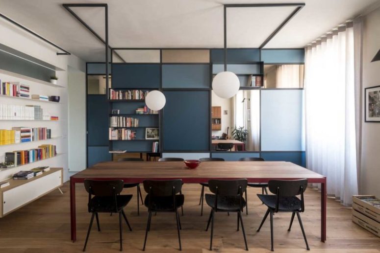The dining space is done with a wooden table and black chairs plus some bubble lamps over it