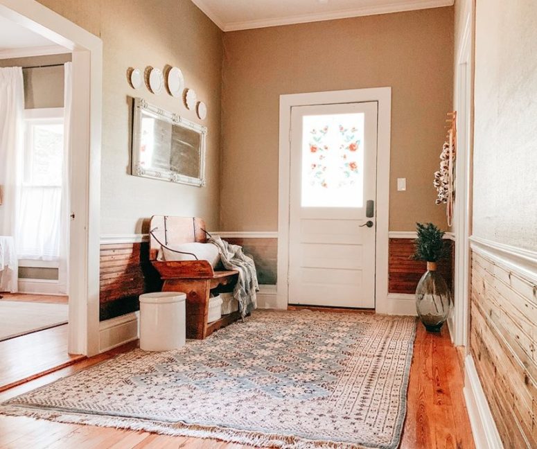a cozy entryway design The entryway is cozy and simple, with a printed rug, some vintage plates and a vintage wooden bench