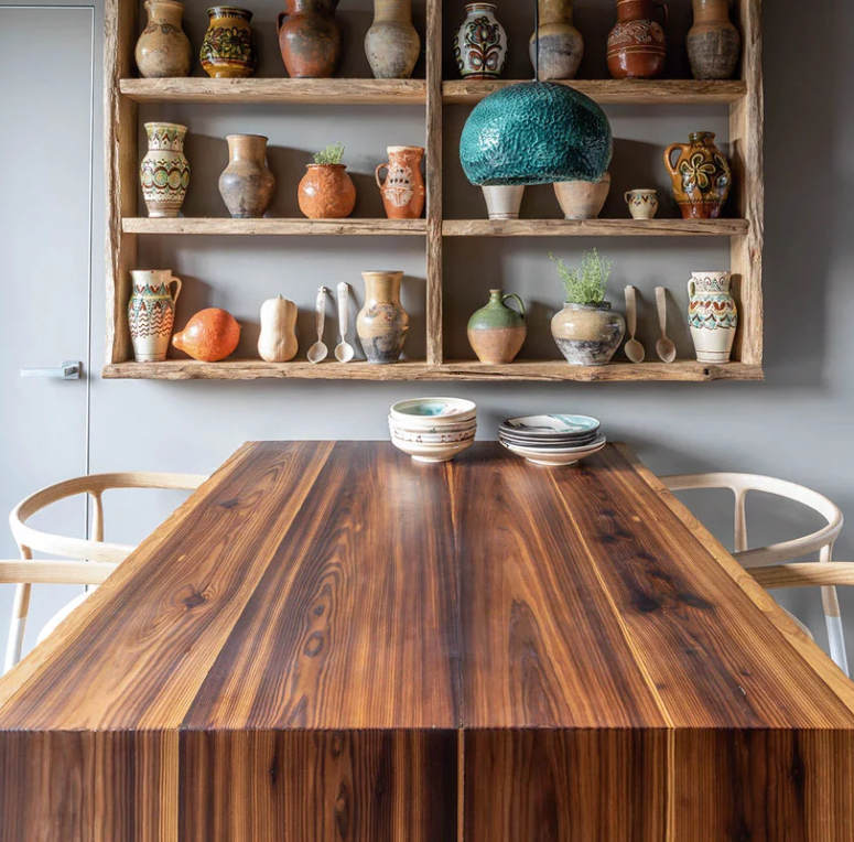 The dining space features a bold table, a creative teal pendant lamp and the rest of the collection of clay