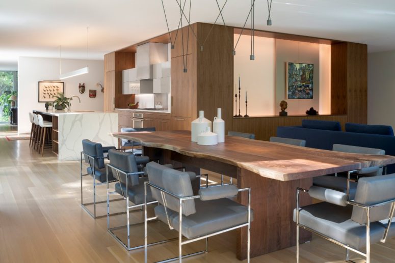 The living, dining rooms and the kitchen are united into one layout and is done with contemporary furniture and lamps