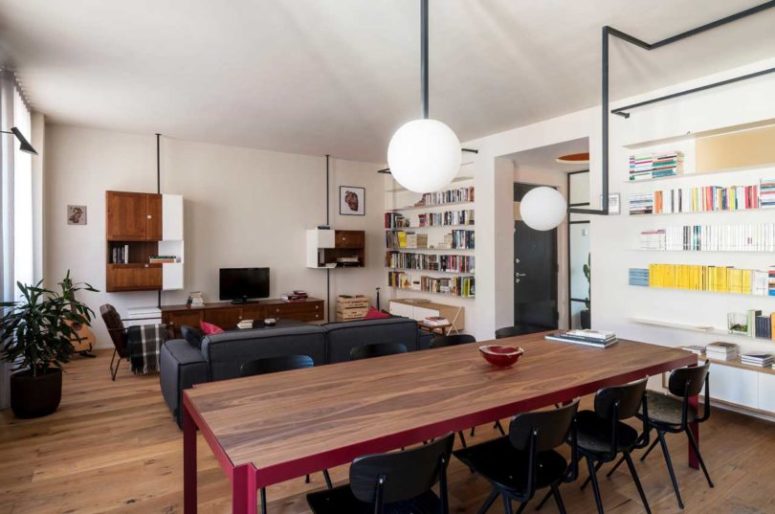 The living room is decorated with mid-century modern furniture and some wall storage units, closed and opened ones