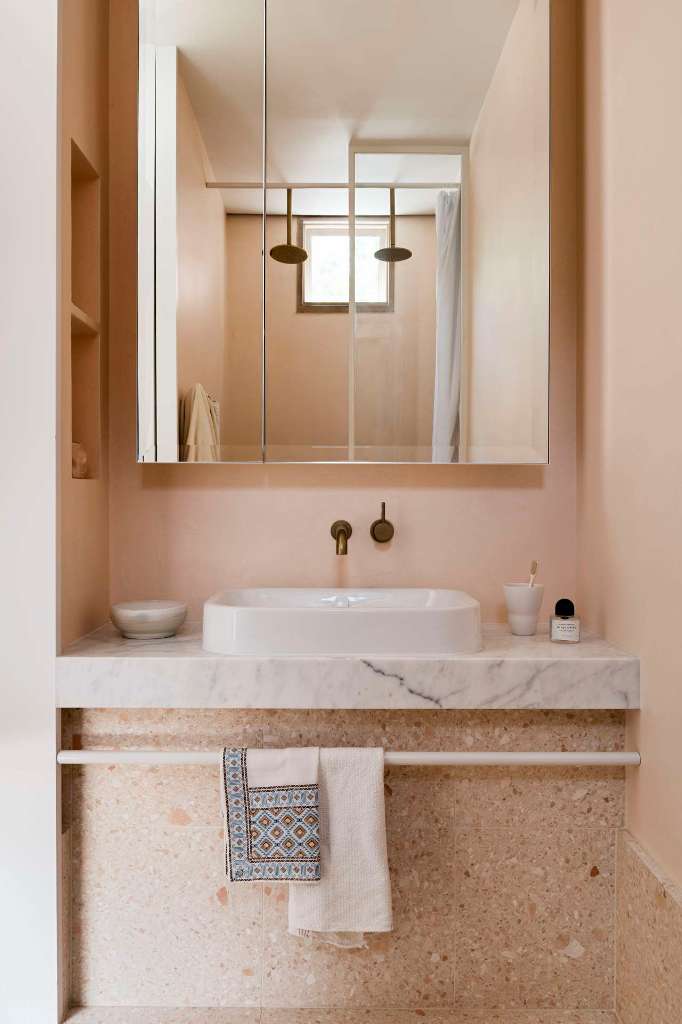 The bathroom is done in light peachy tones, with terrazzo and white marble