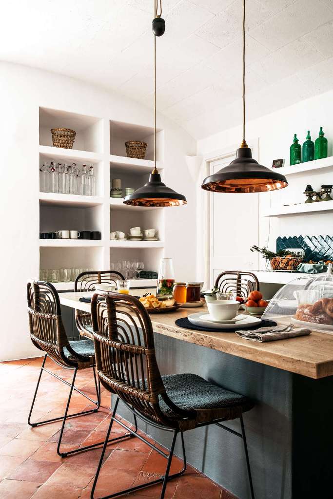The kitchen is cozy and features built in furniture, a kitchen island and rattan chairs and pendant lamps The kitchen is cozy and features built-in furniture, a kitchen island and rattan chairs and pendant lamps