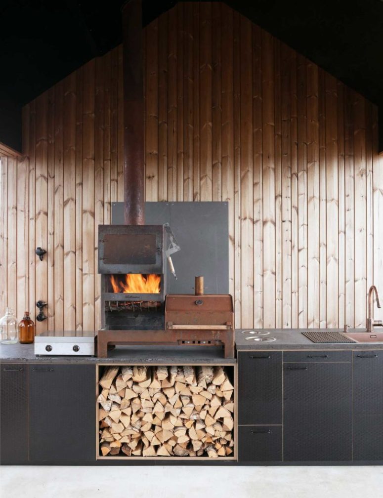 The kitchen is done with a vintage hearth, firewood storage and a stove