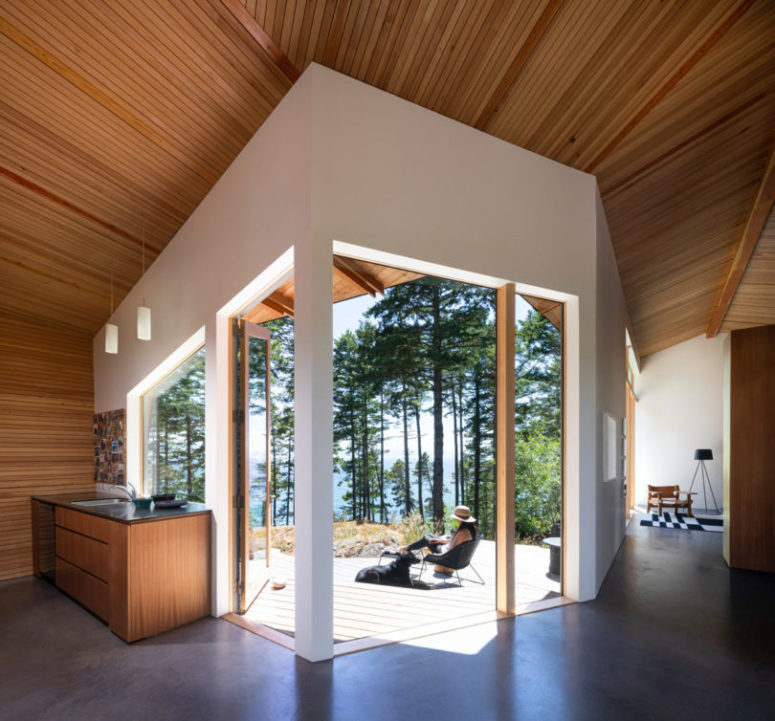 The kitchen features wooden cabinets, pendant lamps and a sink, and this space is fully opened to outdoors with glazed doors The kitchen features wooden cabinets, pendant lamps and a sink, and this space is fully opened to outdoors with glazed doors