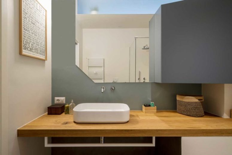 The bathroom continues the decor of the apartment with geometry and colors and some floating furniture