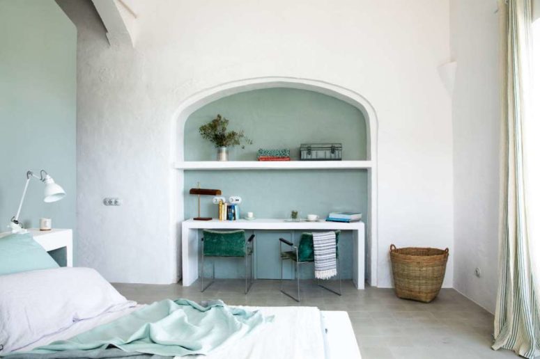 The bedroom is decorated in mint green and white, with a home office zone and a large bed
