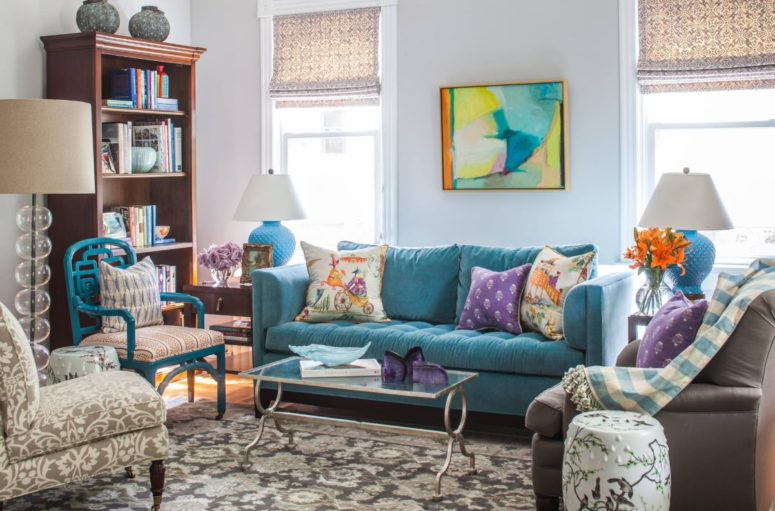 a super bright living room done with colorful furniture, artworks, blooms and accessories for a whimsy feel