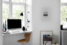 a minimal white workspace with a windowsill desk, a wooden chair, some dramatic touches of black and art