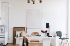 an elegant home office with a wihte desk, plywood chairs, some artworks and bronze touches here and there