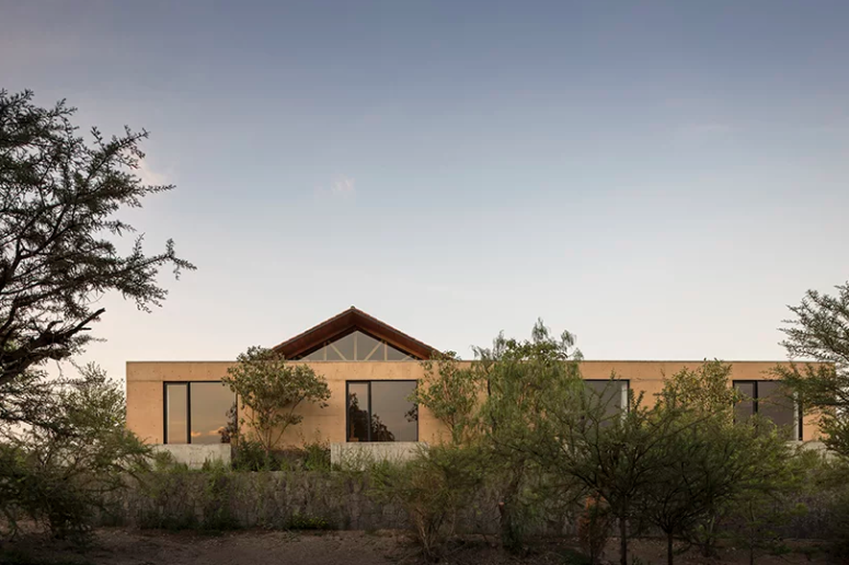 This contemporary home is located in Mexico, it fully adapts to the terrain and merges with nature with its earthy colors