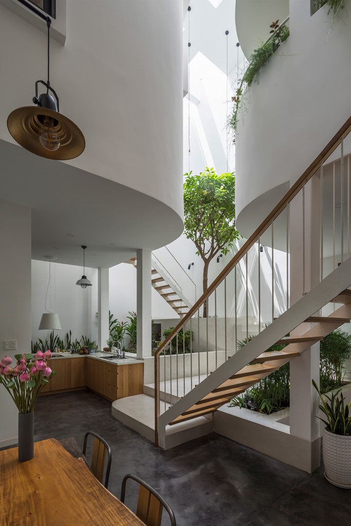 This unique house in Vietnam features a triple height atrium, which fills the spaces with light