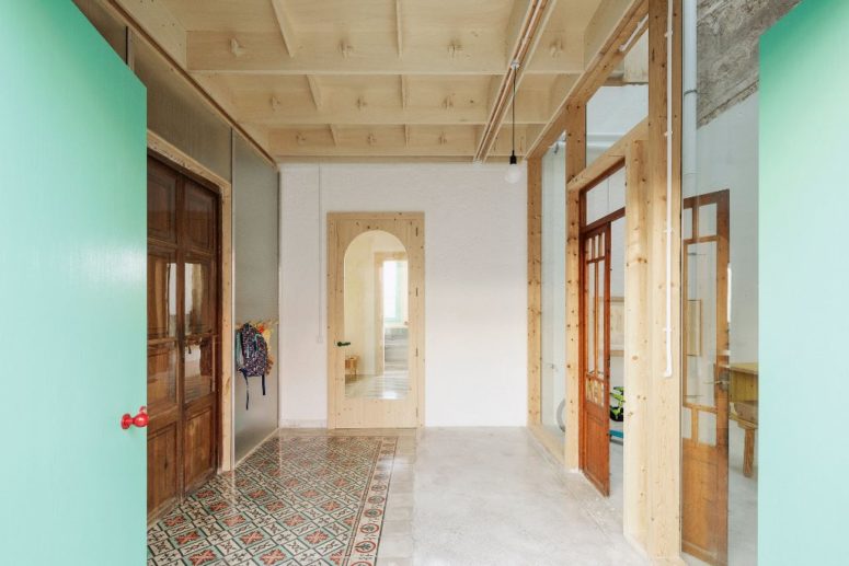 The entryway is done with printed tiles, a plywood ceiling and vintage wooden doors