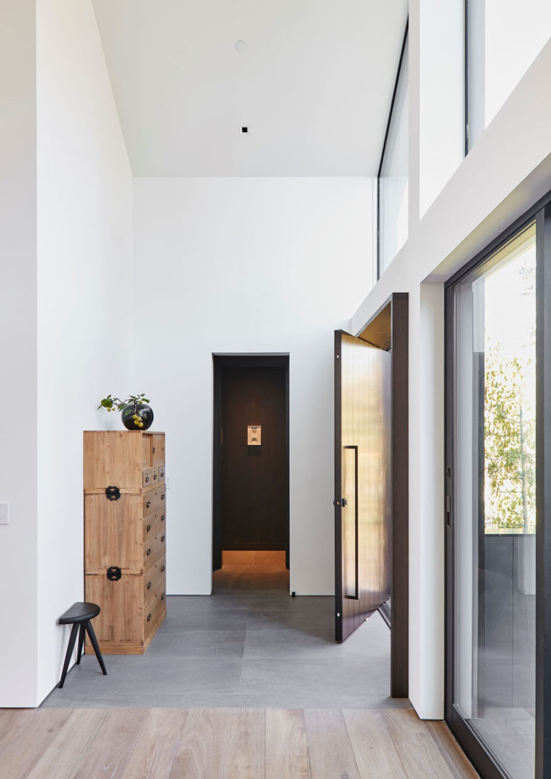 The foyer is light colored and there's a stylish light colored woodne cabinet that feels very vintage like The foyer is light-colored and there's a stylish light-colored woodne cabinet that feels very vintage-like