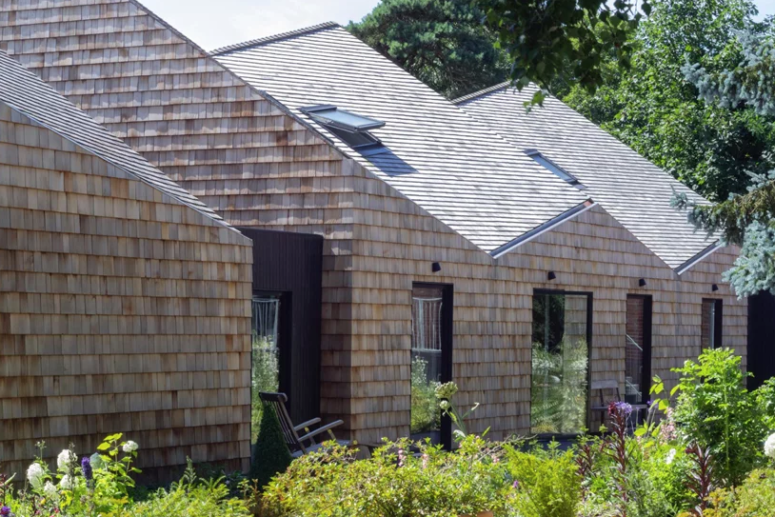The house is fully clad with shingles and it looks like a fresh take on a traditional barn, with sculptural shapes The house is fully clad with shingles and it looks like a fresh take on a traditional barn, with sculptural shapes