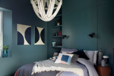 05 The bedroom is done in dark green, with built-in storage units and a comfy bed with lots of pillows