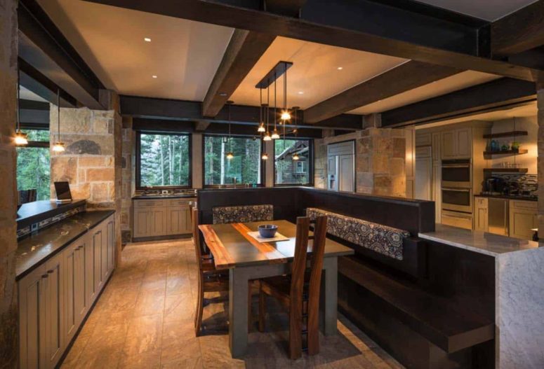 The breakfast nook features a cozy corner sofa and a wooden table plus pendant lights