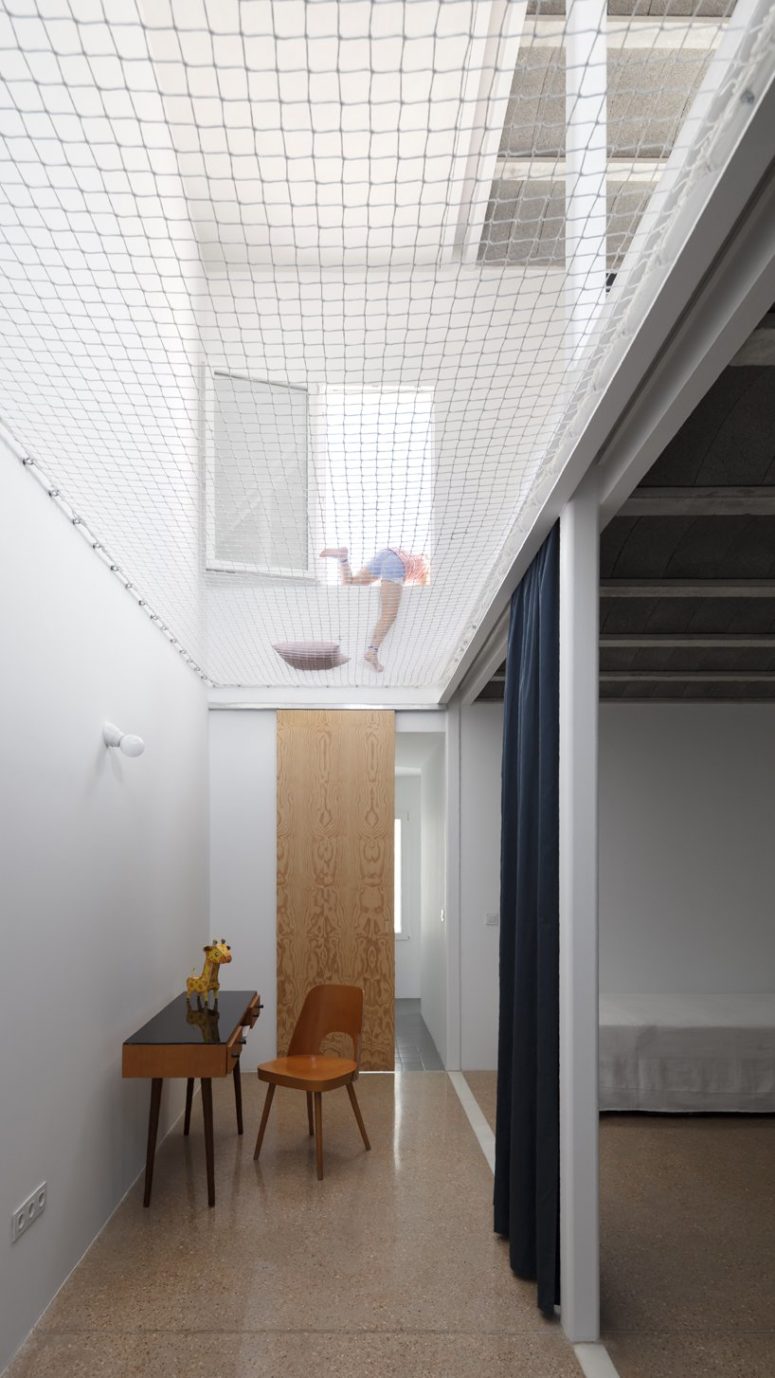 The double height space in the multipurpose room is decorated in a minimal way and with simple furniture The double height space in the multipurpose room is decorated in a minimal way and with simple furniture