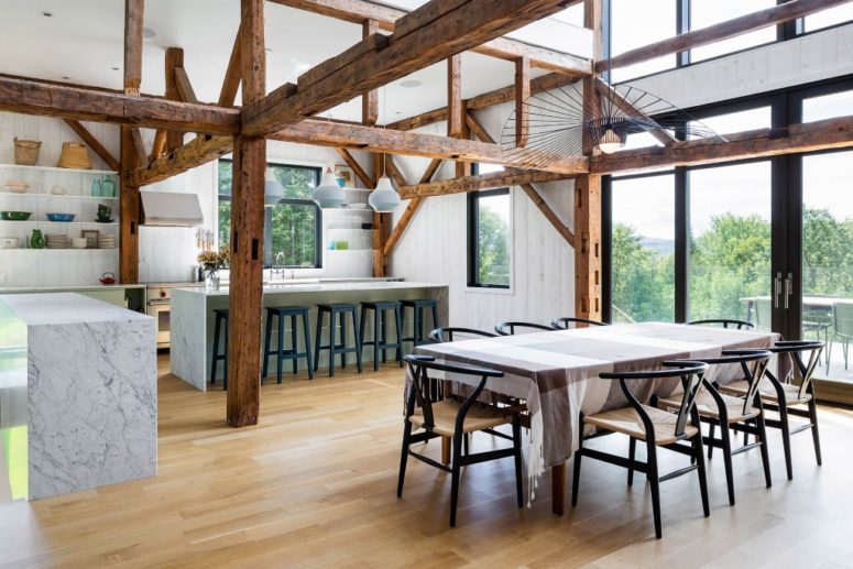 The kitchen and dining space are placed next to each other, with marble kitchen islands, white shelves and comfy chairs The kitchen and dining space are placed next to each other, with marble kitchen islands, white shelves and comfy chairs