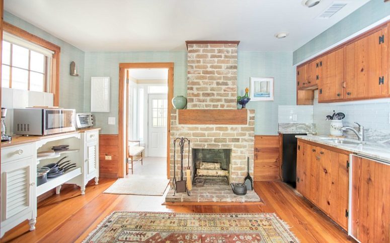 The kitchen is done with rich stained cabinets, light blue walls and backsplashes, a fireplace that is working The kitchen is done with rich stained cabinets, light blue walls and backsplashes, a fireplace that is working