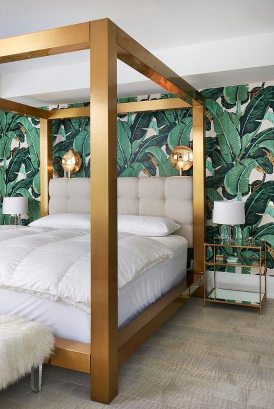 a statement thick brass canopy bed looks bold in this tropical bedroom and adds glam and chic to it