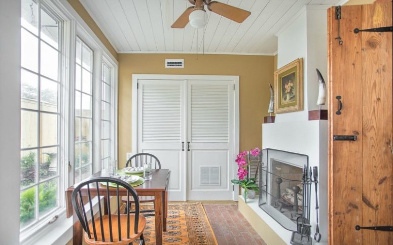 The dining space is done by the glazed wall, there's a chic working fireplace with a metal screen and simple furniture The dining space is done by the glazed wall, there's a chic working fireplace with a metal screen and simple furniture