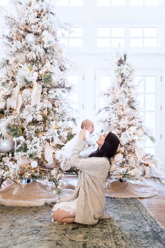 flocked Christmas trees with neutral ornaments, ribbons, berries and lights look very fairy-tale-like