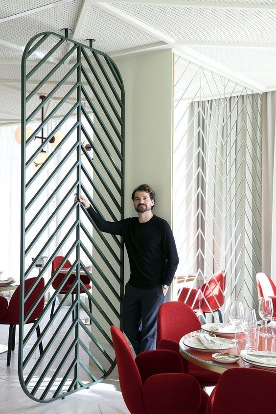an eye-catchy metal space divider in green is a chic and bold idea that matches the space decor and adds geometry to it