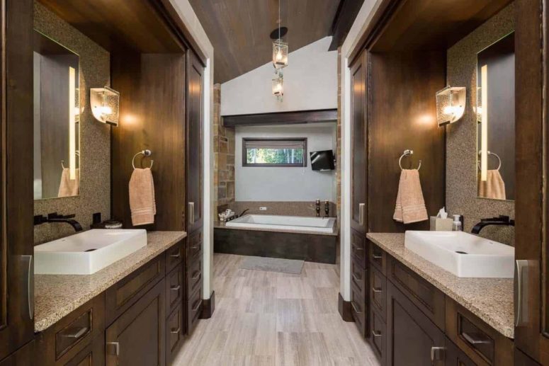 The bathrooms are done with dark wood, stone and glass lamps