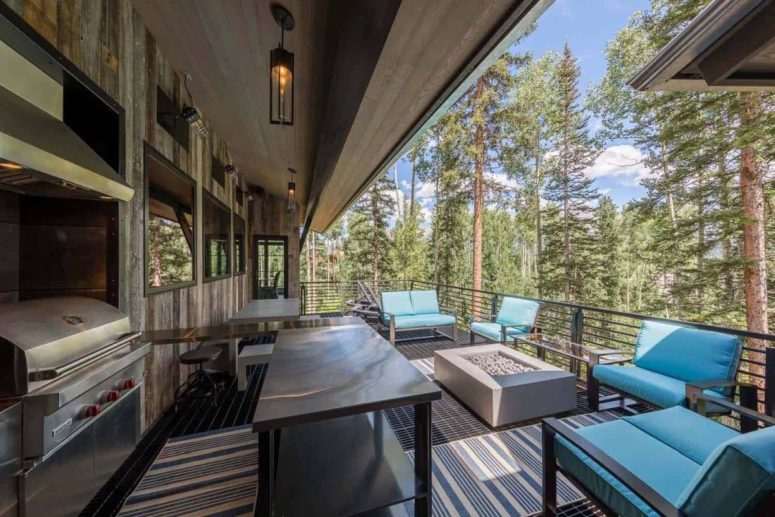 The terrace features a grill and a dining zone plus some blue sofas and chairs