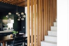 14 a dining space wraped in a vertical wooden plank screen on one side and from above that makes it a design feature