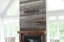 17 a grey reclaimed wood wall with a built-in fireplace is a warming up idea for a living room