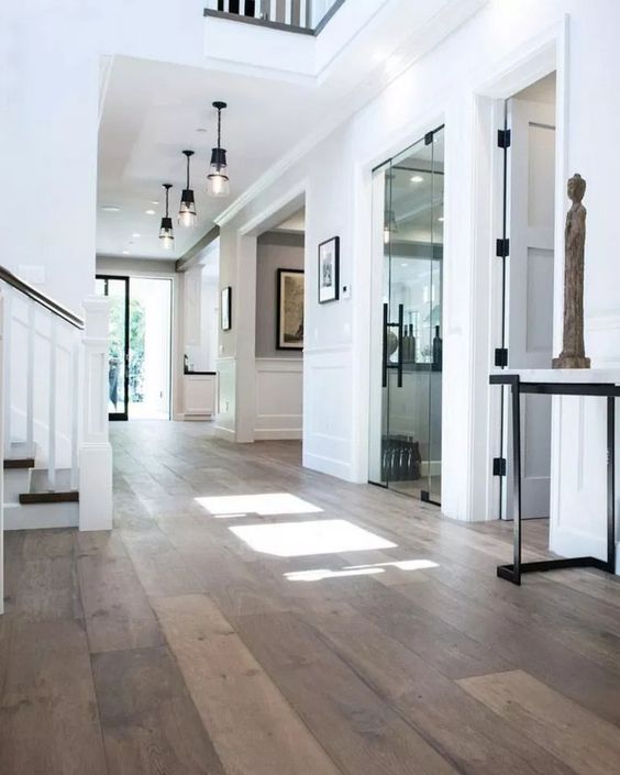a stylish and elegant white space with black touches for drama and warming up hardwood floor