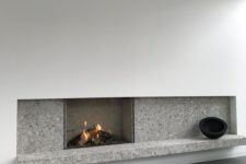 18 a minimalist fireplace with white paneling and grey stone plus some black touches for drama