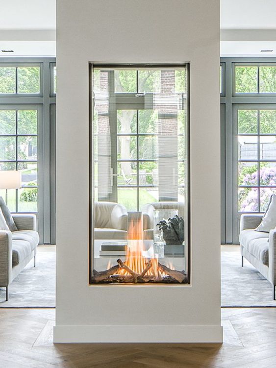 a large glass encased double-sided fireplace is a statement piece for any space