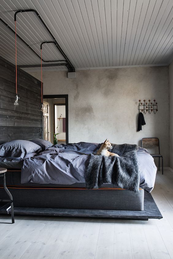 black exposed pipes on the ceiling, a reclaimed wood statement wall for an industrial feel in the space